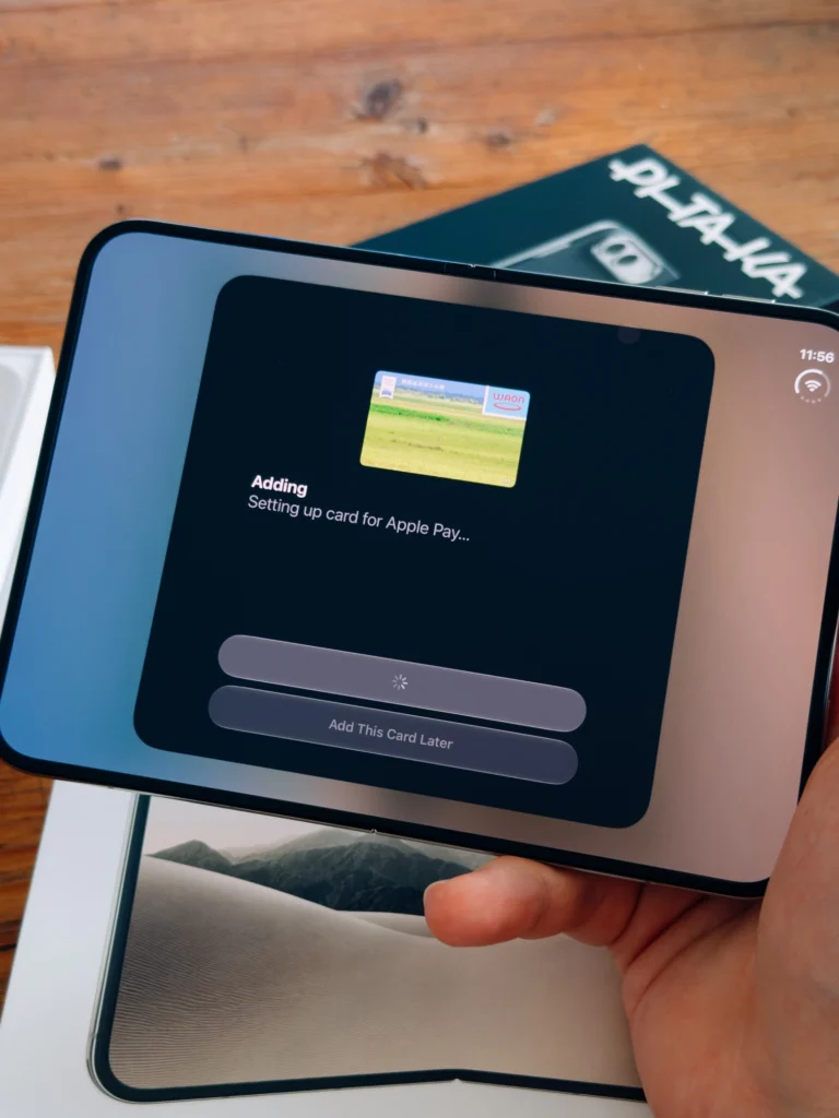 Unfolded iPhone Duo in hand while setting up a card for Apple Pay
